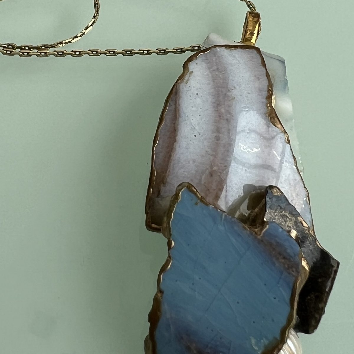 Pendant of blue and white ceramic on a fine gold chain.