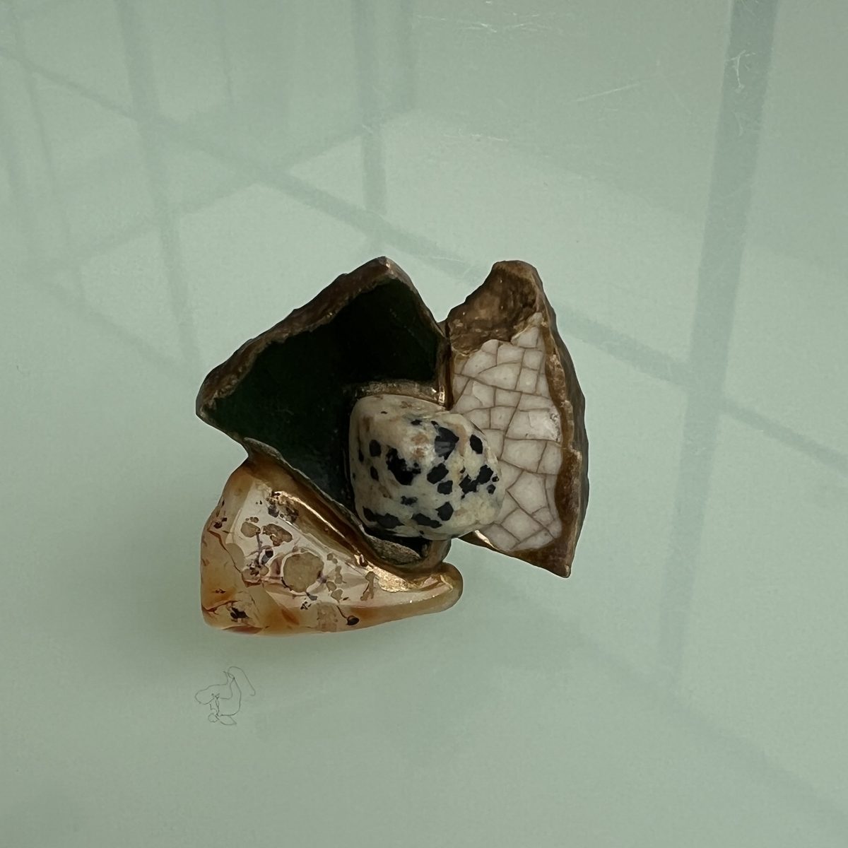 Ring combining deep green, speckled white, and amber ceramic fragments.